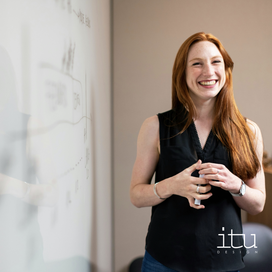 A photo of a smiling office worker using a project room