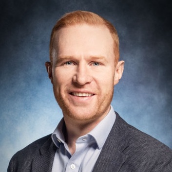 Photo of Rob Fennessy smiling, wearing a smart suit.