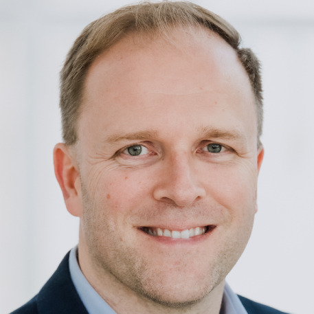 Colour photo of Jarkko Heinonen, smiling, wearing a suit