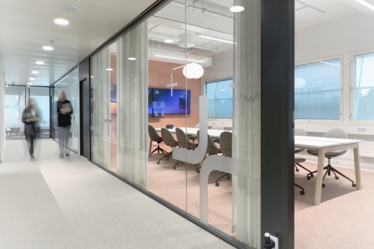 Colour photograph of the offie we designed for Figure. We see a meeting room with peach walls and carpet and fresh lighting.